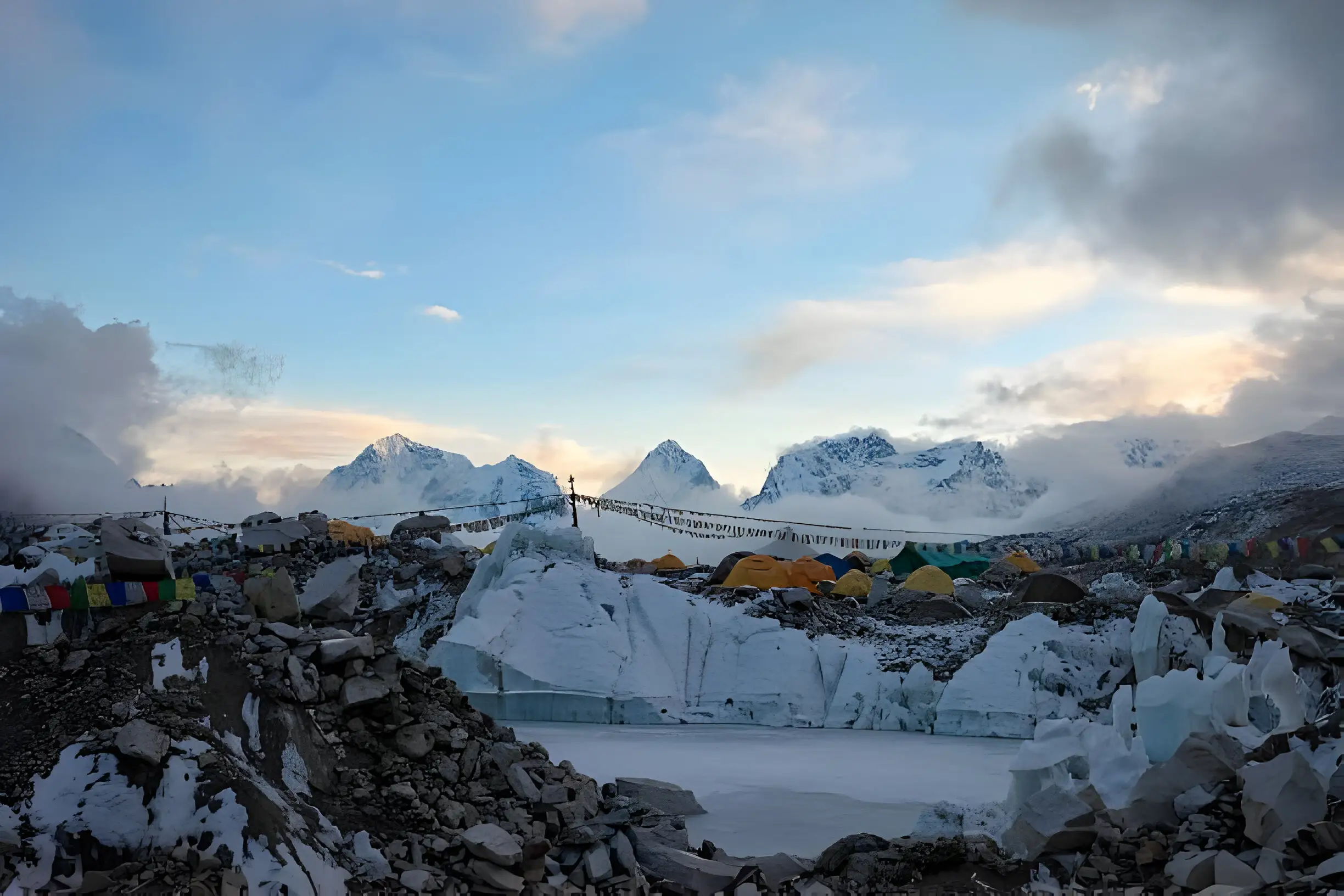 A panoramic view of Everest Base Camp with colorful prayer flags waving in the wind.
