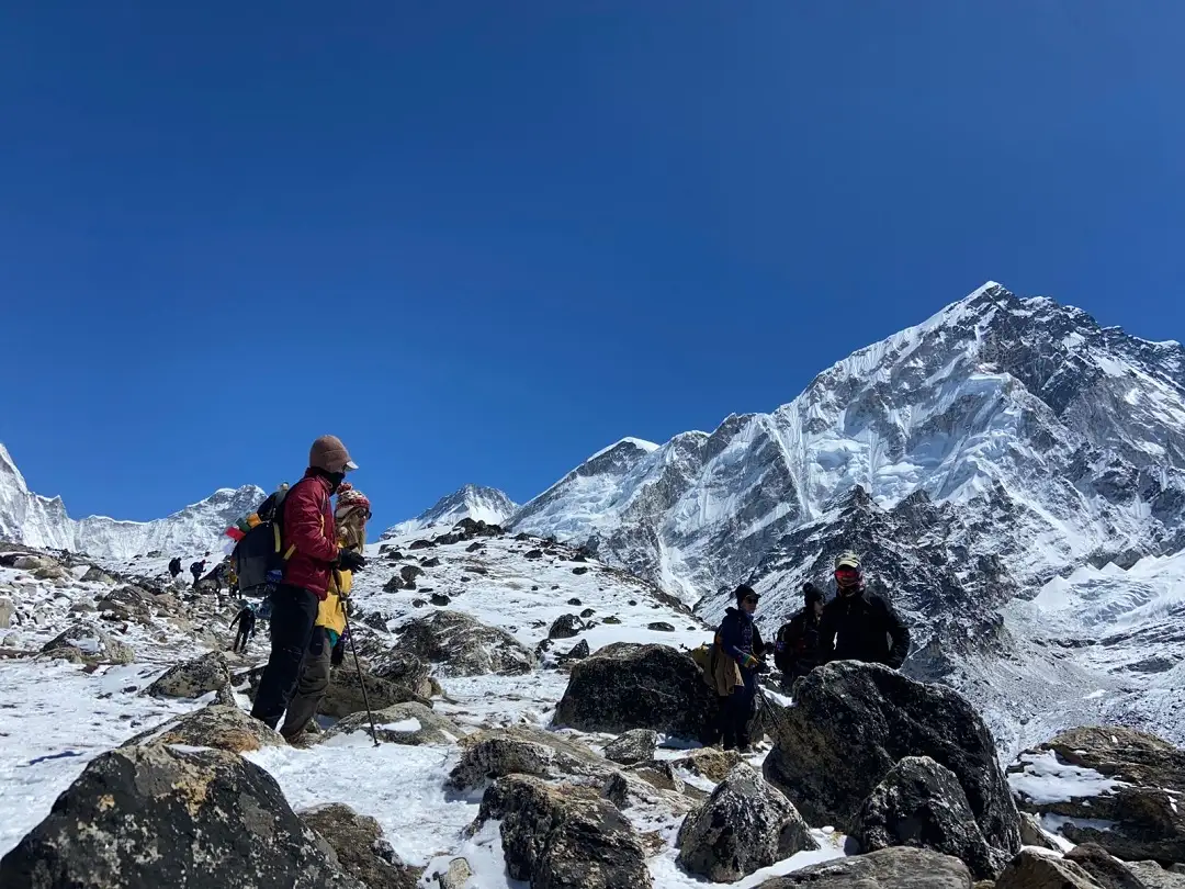 Trekkers traversing a narrow trail with a steep drop-off, demonstrating the need for caution and sure-footedness during the challenging trek to Everest Base Camp.
